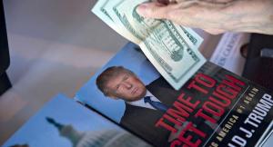 A guest pays for books near a book by Donald Trump, president and chief executive of Trump Organization Inc. and 2016 U.S. presidential candidate, during The Family Leadership Summit in Ames, Iowa, U.S., on Saturday, July 18, 2015. The sponsor, The FAMiLY LEADER, is a "pro-family, pro-marriage, pro-life organization which champions the principle that God is the ultimate leader of the family." Photographer: Daniel Acker/Bloomberg via Getty Images